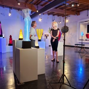 Artist Kevin Caron with Channel 12 reporter Krystle Henderson at the art show Illuminate at Arts HQ in Surprise, Arizona